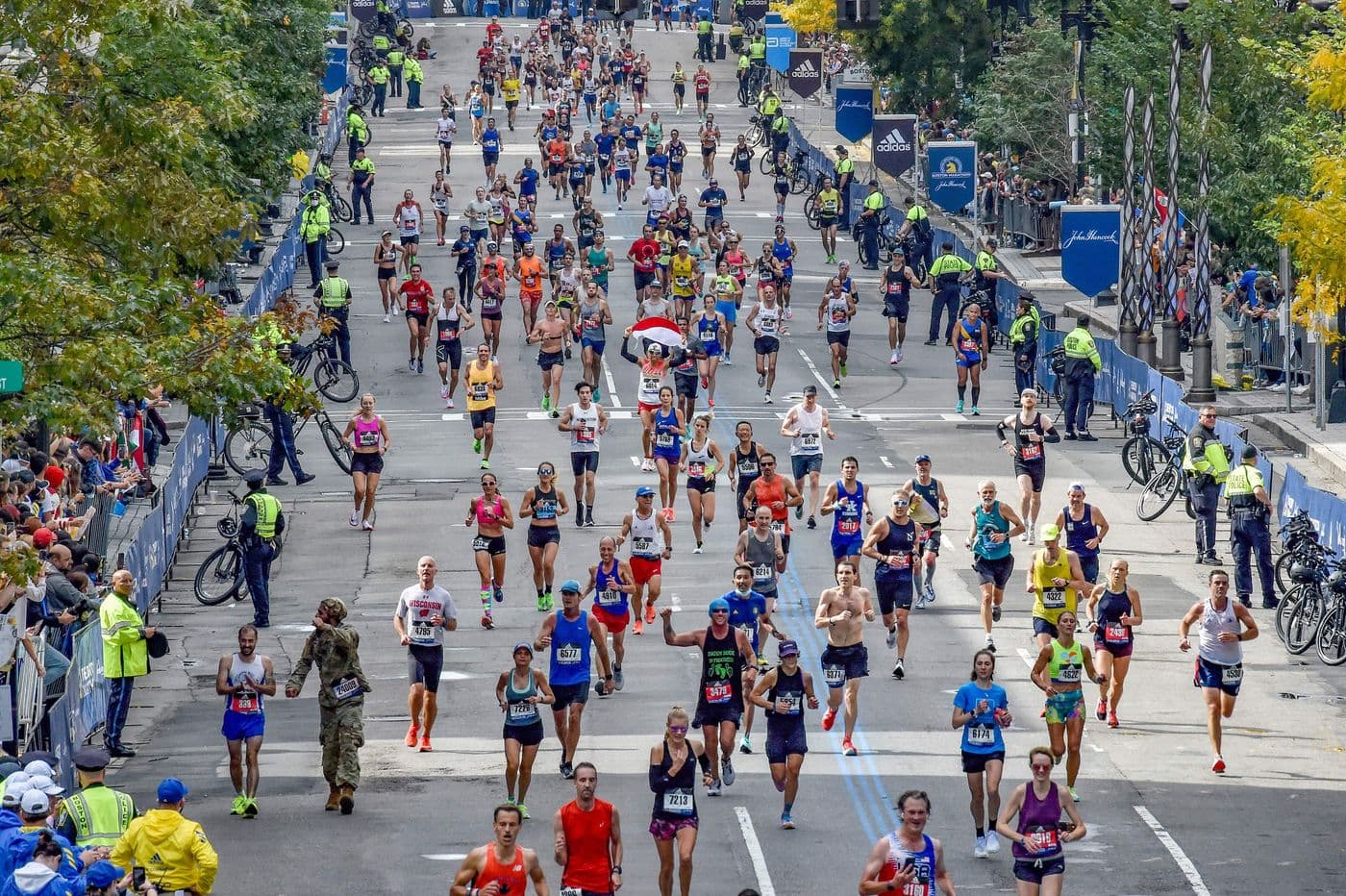 Runners racing through the Boston Marathon and spectators cheering
