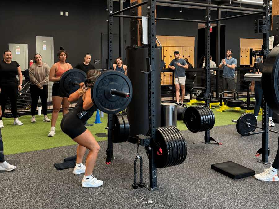 Person lifting a barbell during a strength training class in Boston.