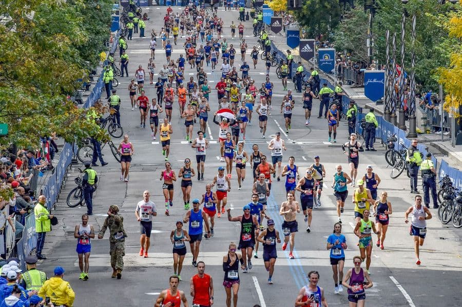 Runners racing through the Boston Marathon and spectators cheering