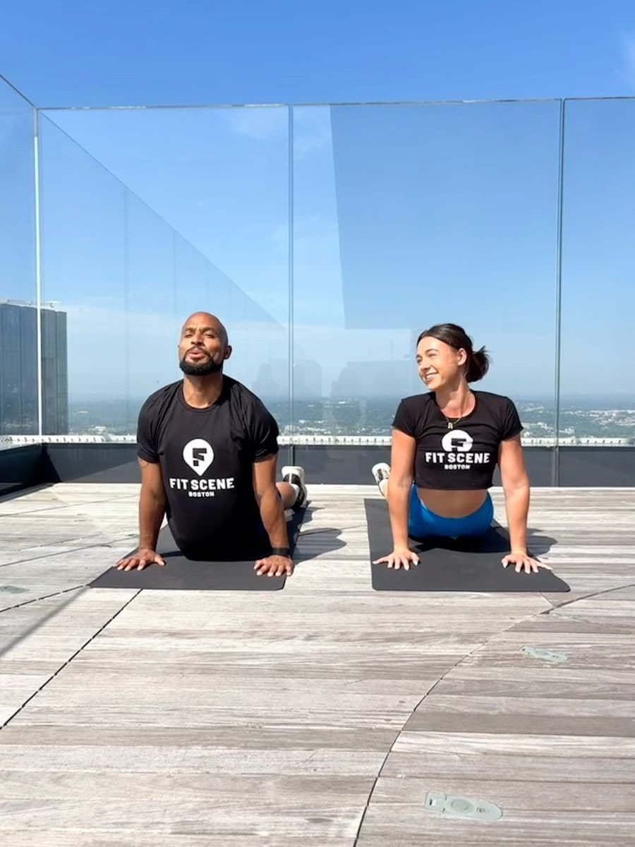 Rylee Abbott and Adrian Bispham, instructors leading Fit Scene Boston and View Boston's Rooftop Wellness Series kickoff event.